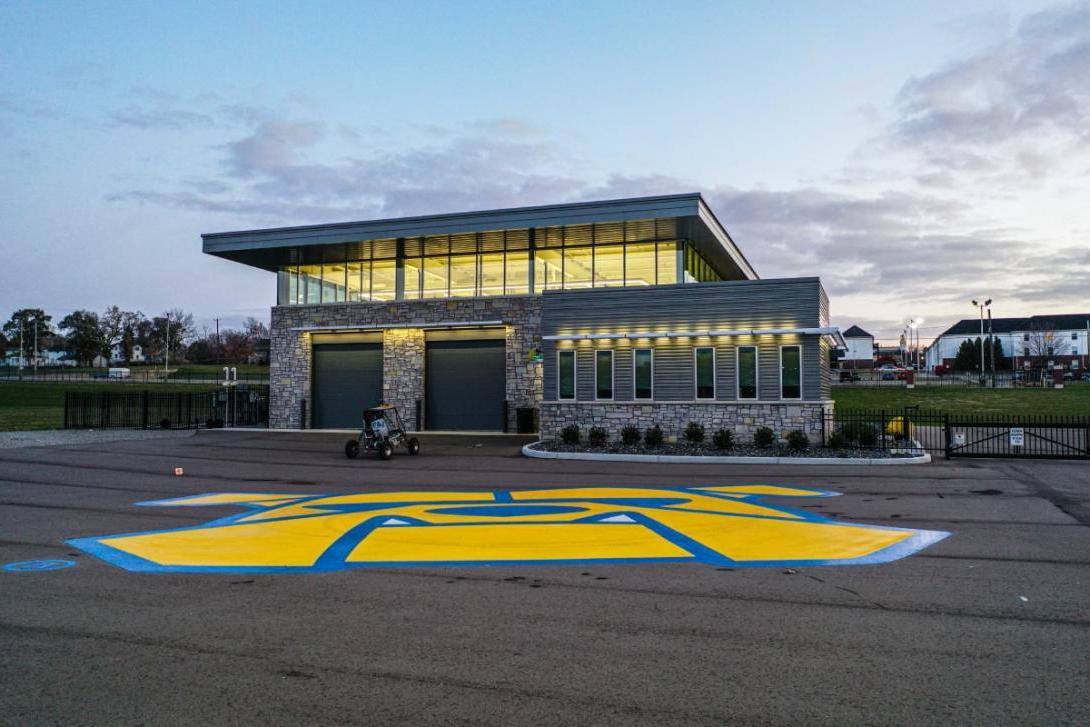 The Kettering GM Mobility Research Center building with a giant bulldog logo painted on the floor in front. 